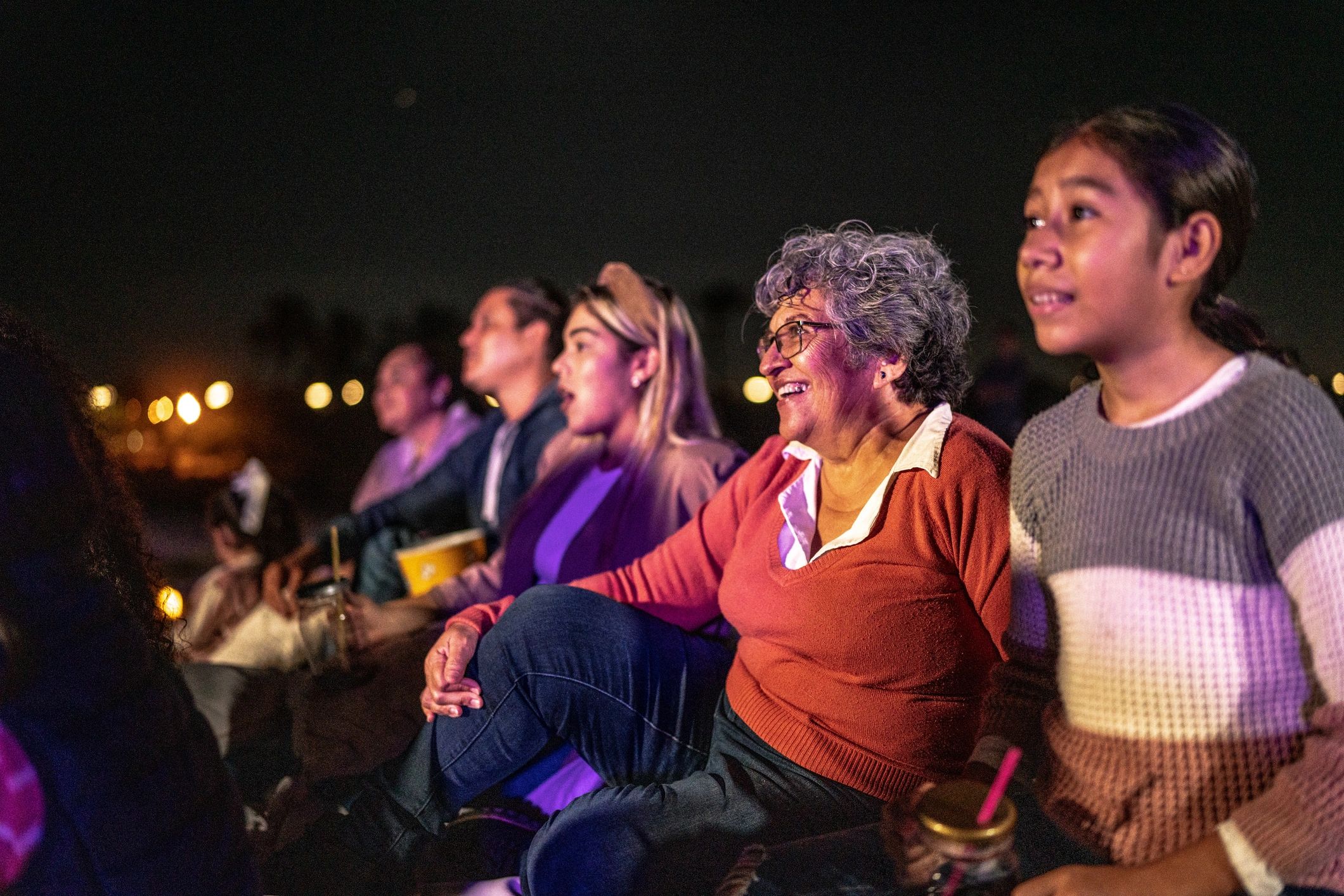 Outdoor cinema crowd enjoying a film at night